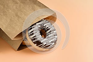Paper bag with chocolate donuts close-up