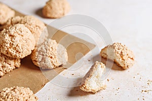 Paper bag with coconut cookies on light concrete background