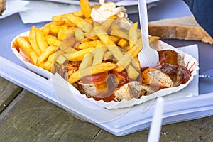 Paper bag with curried sausage and French fries