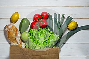 Paper bag of different health food white wooden background