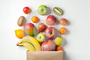 Paper bag of different health fruits on a table