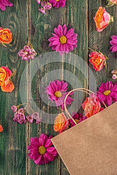 Paper bag with flowers on wooden background, shopping time or time for sales