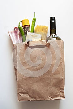 Paper bag with Food supplies, crisis food stock for quarantine isolation period,. salad, pasta, butter,wine,chilli