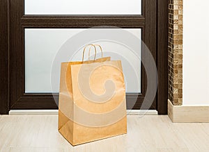 Paper bag near door of house. Safe delivery concept.