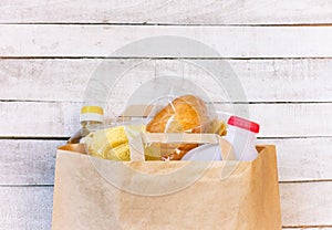 Paper bag with a set of products, sunflower oil, milk, bread, cereals and pasta