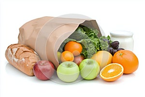 Paper bag spilling fresh groceries, apples, oranges, and bread onto white surface highlighting nutrition and organi photo