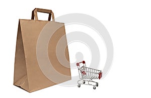 Paper bag and supermarket cart. The concept of selling and buying products.