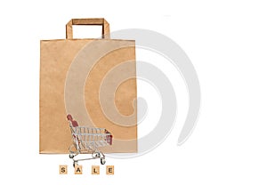 Paper bag and supermarket cart. The concept of selling and buying products