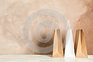 Paper bags on white table against brown background
