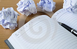 Paper balls and pen over blank white sheet