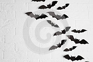 Paper bats on brick wall with space for text