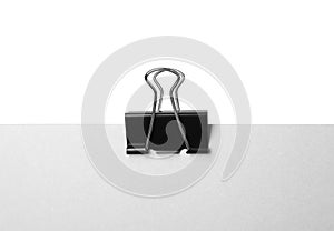 Paper with black binder clip isolated on white