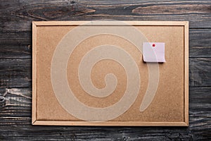 Pinned blank paper note on cork background