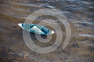 A paper boat of a dollar bill ran aground. Symbolic image