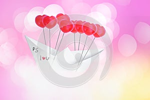 Paper boat with red heart shaped balloon