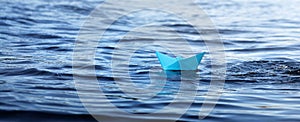 .Paper boat - Sail away, blue small origami boat on the water, panorama of the sea and a toy boat on the waves