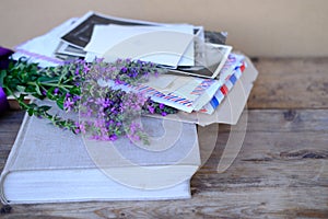 paper book, old photographs, home archive, letter on old wooden table, touching objects of nostalgia, past love, bunch of wild