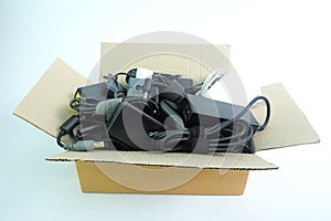 Paper box with the damaged or old used Adapter power charger of laptop computer or electrical appliances on white