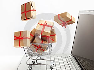 Paper boxes in a shopping cart on a laptop keyboard. Ideas about e-commerce, a transaction of buying or selling goods or