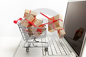 Paper boxes in a shopping cart on a laptop keyboard. Ideas about e-commerce, a transaction of buying or selling goods or