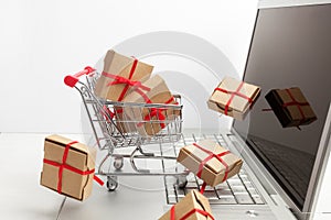 Paper boxes in a shopping cart on a laptop keyboard. Ideas about e-commerce, a transaction of buying or selling goods or