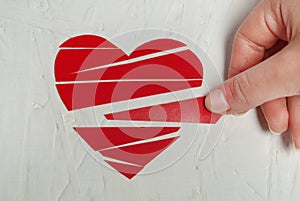 Paper broken heart on white wooden background