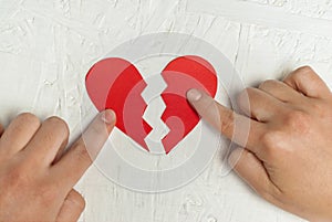 Paper broken heart on white wooden background