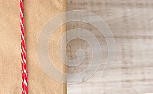 Paper brown box with red and white rope isolated on white background