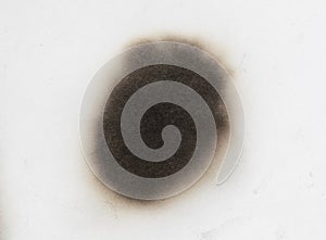 Paper burn black  stain isolated over the white background. Round paper burn mark close up