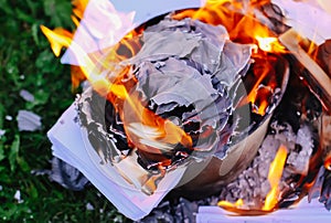 Paper burning on summer grass outdoors.