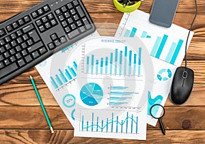 Paper business graphs at office workplace. Business research and report concept. Top view