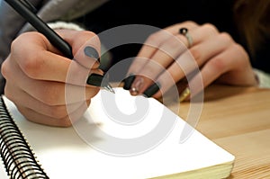 paper in business woman female hand writing notes on a table black manicure and blank letter