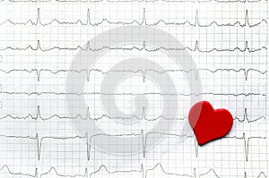 Paper cardiogram of young healthy women and red paper red heart.