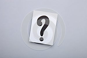 Paper cards with question marks on grey background. Pile of question marks, top view