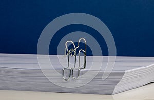 Paper Clip Characters Hugging on Ream of paper