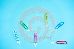 Paper clips on blue background. Different vision creative,