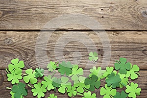 Paper clover leaves on the old wooden background. Lucky shamrock