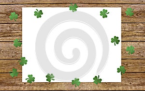 Paper clover leaves on the old wooden background. Lucky shamrock, St.Patrick`s day holiday symbol. Space for text, top view