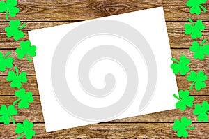 Paper clover leaves on the old wooden background. St.Patrick`s day holiday symbol. Space for text, top view