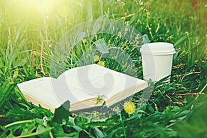 Káva pohár a kniha v tráve 