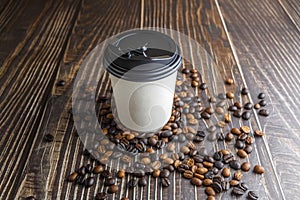Paper coffee cup with coffee beans on wooden table