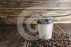 Paper coffee cup with coffee beans on wooden table