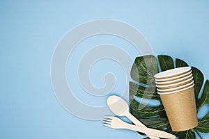 Paper coffee cups made of natural eco-friendly material, on tropical leaves on a blue background