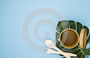 Paper coffee cups made of natural eco-friendly material, on tropical leaves on a blue background