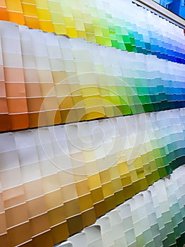 paper color palettes on a shelf in a wall paint supply store, guide of paint samples catalog