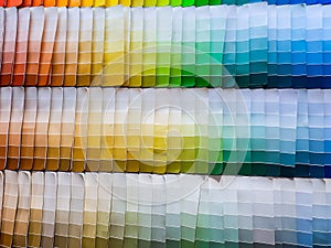 paper color palettes on a shelf in a wall paint supply store, guide of paint samples catalog