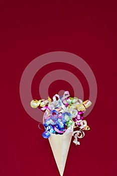 Paper cone with colorful party streamers Viva Magenta background.