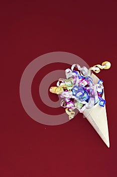 Paper cone with colorful party streamers Viva Magenta background.