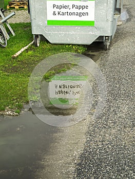 Paper containers by a puddle