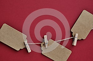 Paper craft discount labels are attached with clothespins to the rope on a red background